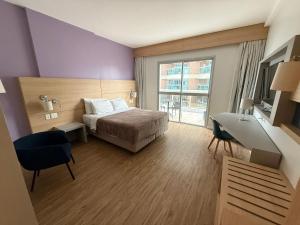 桑托斯Stay Inn Santos Sua acomodação com cara de Hotel的一间卧室，配有一张床、一张书桌和一扇窗户 更多37张照片