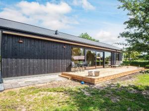 a backyard with a wooden deck and a building at 6 person holiday home in Juelsminde-By Traum in Sønderby