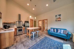 a living room with a blue couch and a kitchen at Casa Moab 4 - In Town - Outdoor Sauna! in Moab