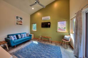 a living room with a blue couch and a tv at Casa Moab 4 - In Town - Outdoor Sauna! in Moab