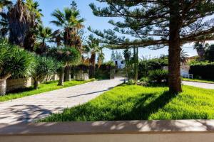 a street with palm trees and a sidewalk at Villa Marzamemi 200 m dal mare in San Lorenzo +29 photos