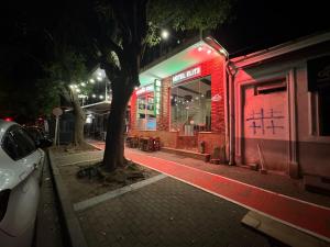 a street at night with a tree and a building at Hotel Elite in Batumi