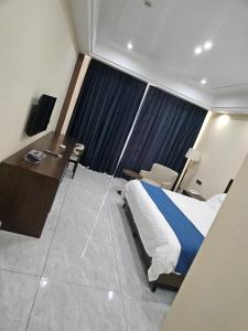 MamaDe Marii Hotel FZE的一间带床和书桌的酒店房间 更多24张照片