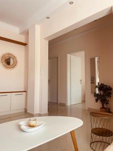 a white table in a room with a plate on it at Fay's Apartment in Nea Vrasna +23 photos