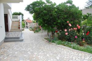 ロパールにあるApartments in Lopar - Insel Rab 17729の家の横にある花が咲いた歩道と階段