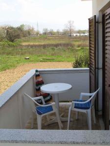 ロパールにあるApartments in Lopar - Insel Rab 17729のテーブルと椅子付きのバルコニー