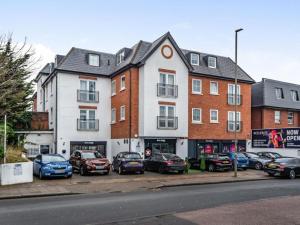 a parking lot with cars parked in front of a building at Spacious 2-bedroom Flat, Edgware London in Edgware