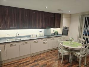 a kitchen with a table and chairs and a sink at Spacious 2-bedroom Flat, Edgware London in Edgware