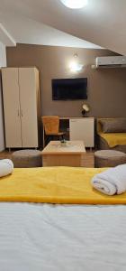 a room with a bed and a couch and a tv at Central Suites in the heart of Ohrid in Ohrid