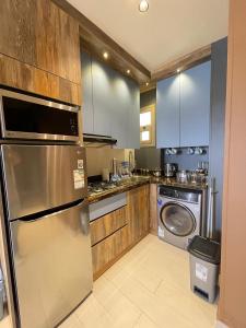 a kitchen with a stainless steel refrigerator and a dishwasher at Luxury Studio House 392-4 in 6th Of October +2 photos