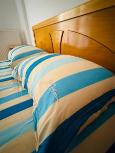 a bed with a blue and white striped blanket at Polivios Apartment in Térsa +12 photos