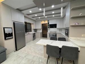 a large kitchen with a table and chairs at شقة واسعة مع ترس كبير in Amman