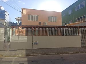 a building with a fence on the side of a street at Bella house in Balneário Camboriú