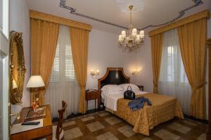 un dormitorio con una cama con un bolso en Lucca in Azzurro Maison de Charme, en Lucca