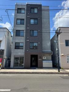 un grand bâtiment au coin d'une rue dans l'établissement Stisfy サティスファイ, à Chitose