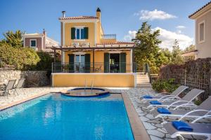 a villa with a swimming pool with chairs and a house at Lassi Seaview Villa Private Pool Villa Efrosini Short Walk To Resort Centre in Kefallonia