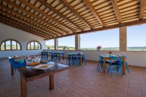 una sala da pranzo con tavoli, sedie e finestre di Relais Piano Valle a Pollutri