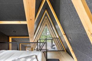 Un dormitorio con una pared negra con una ventana. en La Cabine Hygge, en Saint Roch de Mekinac