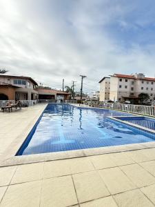 a large swimming pool in a courtyard with buildings at Apartamento 100 metros da praia com piscina in Ilhéus
