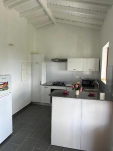 a kitchen with white cabinets and a white refrigerator at Les douceurs de la Baie Terre de Bas in Terre de Bas +10 photos