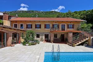 a house with a swimming pool in front of it at Family friendly house with a swimming pool Grizane, Crikvenica - 24302 in Grižane