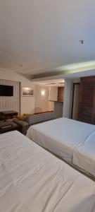 une chambre d'hôtel avec deux lits et un canapé dans l'établissement KUBITSCHEK - JK APART Hotel, à Brasilia 59 autres photos