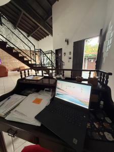 a laptop computer sitting on a desk with a staircase at Pousada Bahan Suites privativas - ideal para Casais in Ubatuba