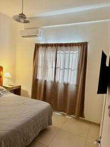 ein Schlafzimmer mit einem Bett und einem Fenster in der Unterkunft Loano III - Confort Moderno en PB! in Belén de Escobar + 23 Fotos