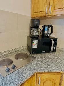 a kitchen counter top with a microwave and a stove at Loano III - Confort Moderno en PB! in Belén de Escobar +18 photos