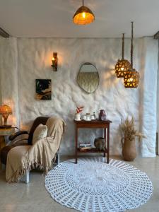 a living room with a table and a chair and a rug at Pousada Tubarão in Arraial d'Ajuda