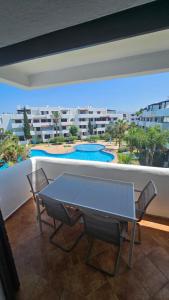 a table and chairs on a balcony with a swimming pool at La cassia in Cabo Negro