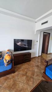 a living room with two beds and a flat screen tv at La cassia in Cabo Negro