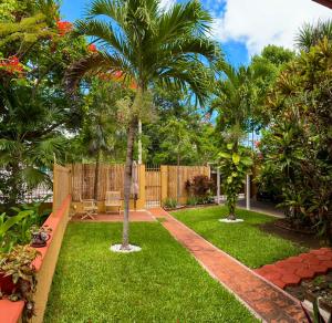 un jardín con palmeras y una valla en Posada San Juan, en Cancún