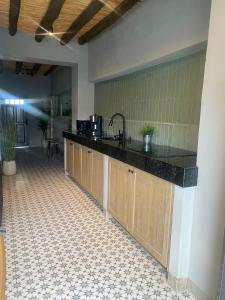 Una cocina con gabinetes de madera y encimera. en Casa Sererno I, en Cuatrociénegas de Carranza