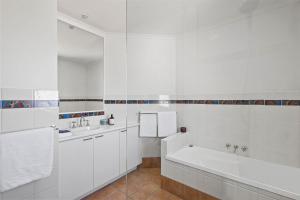 a white bathroom with a tub and a sink at Coastal Luxury at 'Sunshine Central' 3 Bed Penthouse in Sunshine Beach
