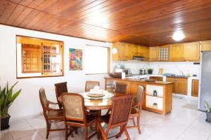 a kitchen with a wooden ceiling and a table and chairs at Villerme Lodge in Papeete