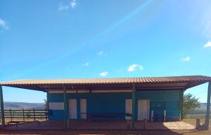 a blue building with a roof on top of it at Camping do edmar in São Roque de Minas