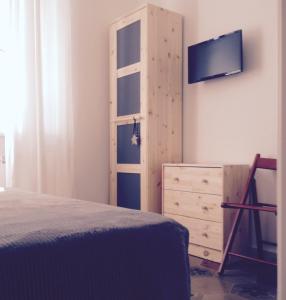 a bedroom with a bed and a tv and a dresser at B&B Giù le Stelle in Marina di Massa