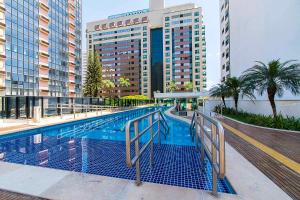 a swimming pool in front of a large building at Apartamento no Athos Bulcão centro de Brasília in Brasilia