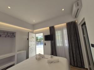 a bedroom with a bed with two towels on it at Cozy White House - Near Beach Private Jacuzzi in Ksamil