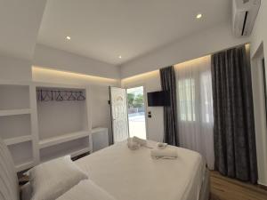 a white bedroom with a bed and a window at Cozy White House - Near Beach Private Jacuzzi in Ksamil +26 photos