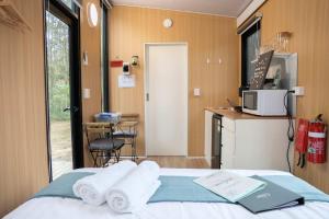 a hotel room with a bed with towels on it at Rocky Creek Escape by Tiny Away in Kanighan