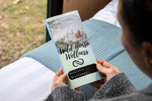 a person holding a book in their hands at Rocky Creek Escape by Tiny Away in Kanighan +21 photos