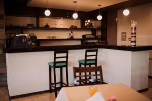 a bar with two green stools in a restaurant at Hotel Maggio in Malargüe
