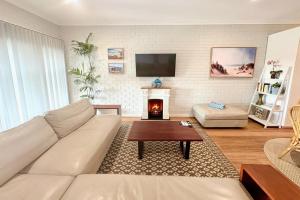 a living room with a couch and a fireplace at Galley Cove House in Geographe