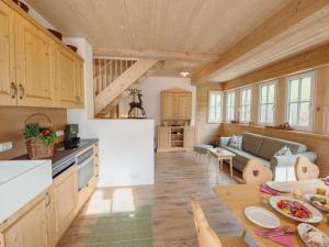 a kitchen and a living room with a table at Chalet near Lake Grundlsee with Sauna in Grundlsee