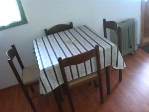 a table with a blue and white striped table and chairs at Dedina kuća 1937 in Mokra Gora