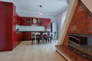 a kitchen and dining room with red cabinets and a fireplace at John's Luxury Apartment in Paralia Katerinis
