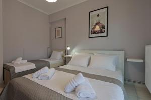 a hotel room with two beds with towels on them at John's Luxury Apartment in Paralia Katerinis