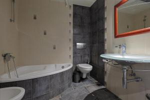 a bathroom with a tub and a toilet and a sink at John's Luxury Apartment in Paralia Katerinis +13 photos